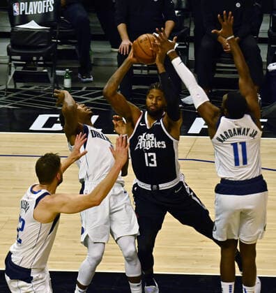 Los Angeles Clippers guard Paul George (13) fouls Dallas Mavericks guard Josh Richardson (0) as he is triple-teamed in the paint during the first half of Game 7 of their first-round playoff series matchup at Staples Center in Los Angeles on June 6, 2021. The Clippers defeated the Mavericks 126-111. They advance to face the top-seeded Jazz starting Tuesday in Utah.  LAP2021060635 JIMxRUYMEN