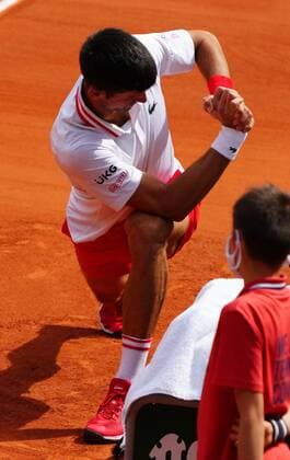 Mandatory Credit: Photo by Javier Garcia BPI Shutterstock (12019129gc) Novak Djokovic stretches as his opponent goes for an injury time out French Open Tennis, Day Nine, Roland Garros, Paris, France - 07 Jun 2021 French Open Tennis, Day Nine, Roland Garros, Paris, France - 07 Jun 2021  Copyright: xJavierxGarcia BPI Shutterstockx 12019129gc