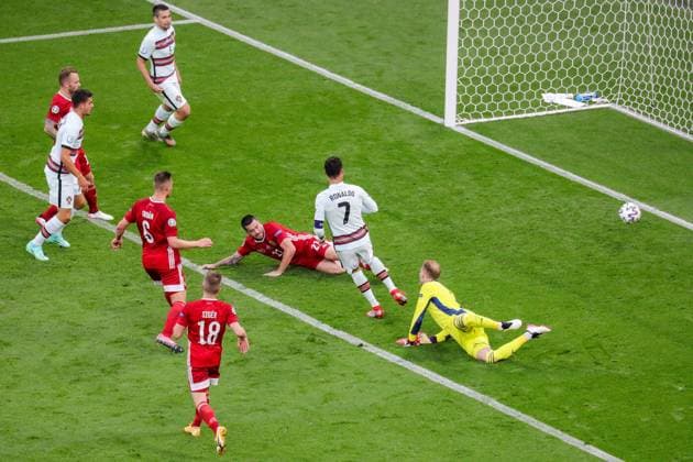 Budapest, Hungary, June 15h 2021: Cristiano Ronaldo (7 Portugal) scores another goal against Goalkeeper P? ter Gulacsi (Hungary) during the European Championship, EM, Europameisterschaft football match between Hungary and Portugal at Puskas Ar? na in Budagpest, Hungary. 