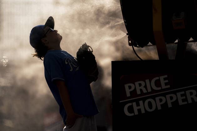 Fans cool off with misting fans on a 100 degree day before the Kansas City Royals verse the Boston Red Sox game at Kaufman Stadium in Kansas City, Missouri on Friday, June 18, 2021.  KCP20210618103 KYLExRIVAS