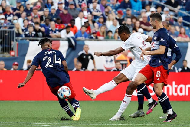 FOXBOROUGH, MA - JUNE 23: New York Red Bulls forward Fabio Gomes Netto (9) gets a shot off between New England Revolution midfielder DeJuan Jones (24) and New England Revolution midfielder Matt Polster (8) during a match between the New England Revolution and the New York Red Bulls on June 23, 2021 at Gillette Stadium in Foxborough, Massachusetts. (Photo by Fred Kfoury III Icon Sportswire) SOCCER: JUN 23 MLS, Fussball Herren, USA - New York Red Bulls at New England Revolution Icon482210623015