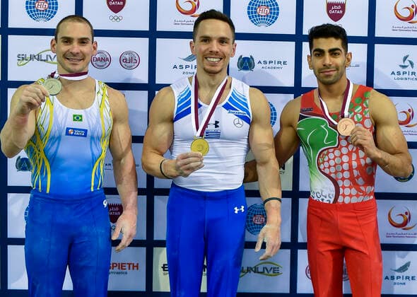 (210626) -- DOHA, June 26, 2021 -- Gold medalist Eleftherios Petrounias (C) of Greece poses with silver medalist Arthur Zanetti (L) of Brazil and bronze medalist Mahdi Ahmad Kohani of Iran during the awarding ceremony for the Men s Rings Final at the 13th FIG Artistic Gymnastics World Cup in Doha, capital of Qatar, on June 25, 2021. (Photo by Nikku Xinhua) (SP)QATAR-DOHA-GYMNASTICS-WORLD CUP yangyuanyong 