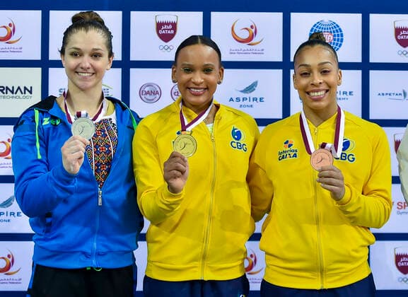 (210626) -- DOHA, June 26, 2021 -- Gold medalist Rebeca Andrade (C) of Brazil, silver medalist Anastasiia Bachynska (L) of Ukraine and bronze medalist Lorrane Oliveira of Brazil pose during the awarding ceremony for the Women s Uneven Bars Final at the 13th FIG Artistic Gymnastics World Cup in Doha, capital of Qatar, on June 25, 2021. (Photo by Xinhua) (SP)QATAR-DOHA-GYMNASTICS-WORLD CUP Nikku 