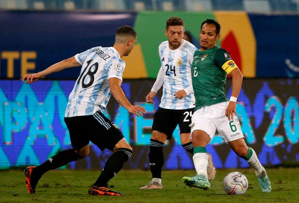 CUIABA, BRAZIL - JUNE 28: Leonel Justiniano of Bolivia competes for the ball with Guido Rodriguez and Alejandro Papu Gomez of Argentina ,during the match between Bolivia and Argentina as part of Conmebol Copa America Brazil 2021 at Estadio Arena Pantanal on June 28, 2021 in Cuiaba, Brazil. SPO, SOC, ICH 