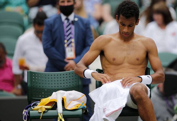 Mandatory Credit: Photo by Shutterstock (12196120bp) Felix Auger Aliassime of Canada changes shirts Wimbledon Tennis Championships, Day 7, The All England Lawn Tennis and Croquet Club, London, UK - 05 Jul 2021 Wimbledon Tennis Championships, Day 7, The All England Lawn Tennis and Croquet Club, London, UK - 05 Jul 2021  Copyright: xShutterstockx 12196120bp