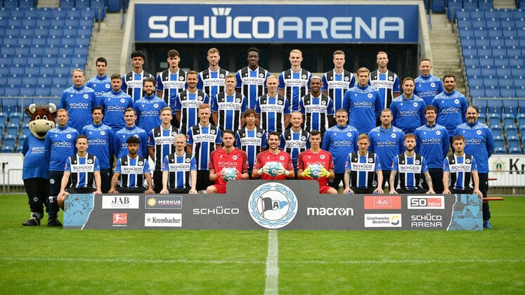 Bielefeld, Schueco Arena, 09.07.21, GER, Herren, 1.Bundesliga, Saison 2021-2022, DSC Arminia Bielefeld - Porträttermin2021 Mannschaftsfoto Teamfoto Bild: Vordere Reihe von links: Cedric Brunner, Noel Niemann, Jomaine Consbruch, Oscar Linner, Stefan Ortega Moreno, Arne Schulz, Jacob Laursen, Marcel Hartl, Vladislav Cherny. Zweite Reihe von links: Maskottchen Lohmann, Frank Kramer (Cheftrainer), Ilia Gruev (Co-Trainer), Sebastian Hille (Co-Trainer), Sebastian Müller, Christian Gebauer, Masaya Okugawa, Sebastian Vasiliadis, Antonio Gonzalez (Betreuer), Michael Schweika (MSc. Ost Physiotherapeut & Osteopath), Mario Bertling (Physiotherapeut), Samuel da Costa (Masseur). Dritte Reihe von links: Marco Kostmann (Torwart-Trainer), Stefan Kleineheismann (Co-Trainer), Niklas Klasen (Athletik-Trainer), Manuel Prietl, Joakim Nilsson, Florian Krüger, Nathan de Medina, Dr. Stefan Budde (Mannschaftsarzt), Dr. Andreas Elsner (Leitender Mannschaftsarzt), Timur Nakip (Video-Analyst). Hintere Reihe von links: Rafael Gameiro (Video-Analyst), Guilherme Ramos, Janni Serra, Fabian Klos, Bryan Lasme, Amos Pieper, Fabian Kunze, Mike van der Hoorn, Rainer Schonz (Zeugwart). Auf dem Foto fehlen: Dr. Tim Niedergassel (Mannschaftsarzt), Philipp Heithölter (Video-Analyst). Nur fuer journalistische Zwecke! Only for editorial use! Gemaess den Vorgaben der DFL Deutsche Fußball Liga ist es untersagt, in dem Stadion und oder vom Spiel angefertigte Fotoaufnahmen in Form von Sequenzbildern und oder videoaehnlichen Fotostrecken zu verwerten bzw. verwerten zu lassen. DFL regulations prohibit any use of photographs as image sequences and or quasi-video. Nordrhein-Westfalen Deutschland