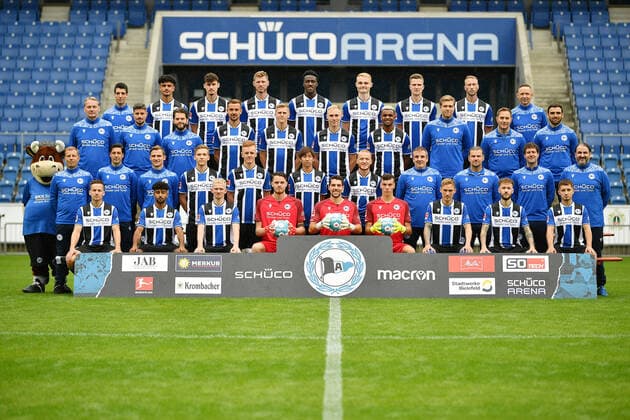 Bielefeld, Schueco Arena, 09.07.21, GER, Herren, 1.Bundesliga, Saison 2021-2022, DSC Arminia Bielefeld - Porträttermin2021 Mannschaftsfoto Teamfoto Bild: Vordere Reihe von links: Cedric Brunner, Noel Niemann, Jomaine Consbruch, Oscar Linner, Stefan Ortega Moreno, Arne Schulz, Jacob Laursen, Marcel Hartl, Vladislav Cherny. Zweite Reihe von links: Maskottchen Lohmann, Frank Kramer (Cheftrainer), Ilia Gruev (Co-Trainer), Sebastian Hille (Co-Trainer), Sebastian Müller, Christian Gebauer, Masaya Okugawa, Sebastian Vasiliadis, Antonio Gonzalez (Betreuer), Michael Schweika (MSc. Ost Physiotherapeut & Osteopath), Mario Bertling (Physiotherapeut), Samuel da Costa (Masseur). Dritte Reihe von links: Marco Kostmann (Torwart-Trainer), Stefan Kleineheismann (Co-Trainer), Niklas Klasen (Athletik-Trainer), Manuel Prietl, Joakim Nilsson, Florian Krüger, Nathan de Medina, Dr. Stefan Budde (Mannschaftsarzt), Dr. Andreas Elsner (Leitender Mannschaftsarzt), Timur Nakip (Video-Analyst). Hintere Reihe von links: Rafael Gameiro (Video-Analyst), Guilherme Ramos, Janni Serra, Fabian Klos, Bryan Lasme, Amos Pieper, Fabian Kunze, Mike van der Hoorn, Rainer Schonz (Zeugwart). Auf dem Foto fehlen: Dr. Tim Niedergassel (Mannschaftsarzt), Philipp Heithölter (Video-Analyst). Nur fuer journalistische Zwecke! Only for editorial use! Gemaess den Vorgaben der DFL Deutsche Fußball Liga ist es untersagt, in dem Stadion und oder vom Spiel angefertigte Fotoaufnahmen in Form von Sequenzbildern und oder videoaehnlichen Fotostrecken zu verwerten bzw. verwerten zu lassen. DFL regulations prohibit any use of photographs as image sequences and or quasi-video. Nordrhein-Westfalen Deutschland