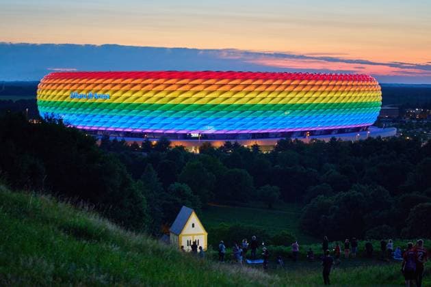 People on the Fröttmaninger Müllberg on the occasion of Christopher Street Day in Munich, the Allianz Arena is illuminated in rainbow colors, which symbolize the colors of the LBGTQ movement in Munich. Bavaria, Germany, July 10, 2021. LGBTQ stands for lesbian, gay, bisexual, transgender, and questioning (or queer).