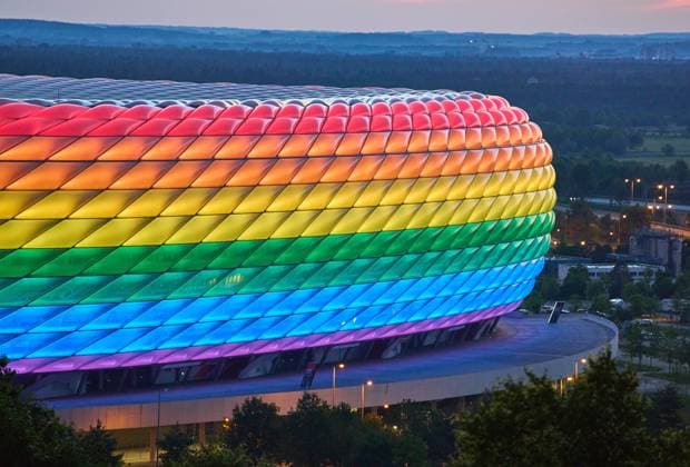 People on the Fröttmaninger Müllberg on the occasion of Christopher Street Day in Munich, the Allianz Arena is illuminated in rainbow colors, which symbolize the colors of the LBGTQ movement in Munich. Bavaria, Germany, July 10, 2021. LGBTQ stands for lesbian, gay, bisexual, transgender, and questioning (or queer).