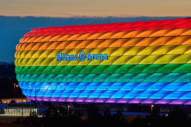 People on the Fröttmaninger Müllberg on the occasion of Christopher Street Day in Munich, the Allianz Arena is illuminated in rainbow colors, which symbolize the colors of the LBGTQ movement in Munich. Bavaria, Germany, July 10, 2021. LGBTQ stands for lesbian, gay, bisexual, transgender, and questioning (or queer).