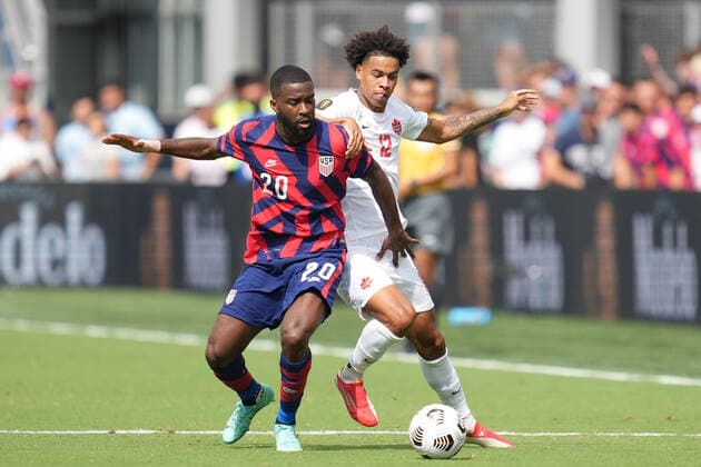 KANSAS CITY, KS - JULY 18: Canada forward Tajon Buchanan (12) battles with United States defender Shaq Moore (20) in action during the CONCACAF Gold Cup Group B match between the United States and Canada on July 18, 2021 at Children s Mercy Park in Kansas City, KS. (Photo by Robin Alam Icon Sportswire) SOCCER: JUL 18 Concacaf Gold Cup - USA v Canada Icon164210718031