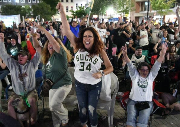 July 20, 2021, Racine, Wisconsin, USA: LAURA LAZNICKA, left, THERESA SCHIFFER, and TRACEY LARRIN cheer as a crowd estimated at up to 1,000 people watches the final minutes of the Milwaukee Bucks 105-98 victory over the Phoenix Suns to win the NBA, Basketball Herren, USA Championship at the â€oeDeer District Downtown†in Racine, Wisconsin Tuesday July 20, 2021. It was their first championship in 50 years. The â€oeDeer District Downtown,†modeled after the Deer District outside the Bucks arena in Milwaukee, enabled fans to gather on Monument Square in the middle of downtown and watch the game on large screen TVs. Racine USA - ZUMAh154 20210720_znp_h154_001 Copyright: xMarkxHertzbergx