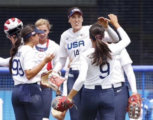 Tokyo Olympics: Softball U.S. pitcher Monica Abbott (14) high-fives teammates after escaping a sixth-inning jam against Canada in the opening round of the Tokyo Olympic softball tournament at Fukushima Azuma stadium in Fukushima, northeastern Japan, on July 22, 2021.  A14AA0000753446P