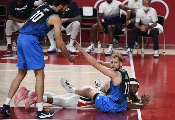 France s Guerschon Yabusele (on the floor) and Slovenia s Jaka Blazic (11) look to the referee for a call on the ball out of bounds as Slovenia s Mike Tobey (10) helps his teammate during Men s Basketball semifinal at the Tokyo 2020 Olympics, Thursday, August 5, 2021, in Tokyo, Japan.  OLY20210805822 MIKExTHEILER
