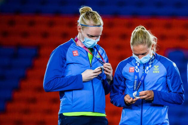 210807 Hedvig Lindahl and Jonna Andersson of Sweden inspect their silver medals during the medal ceremony after the women?s football final during day 14 of the Tokyo 2020 Olympic Games, Olympische Spiele, Olympia, OS on August 6, 2021 in Tokyo. Photo: Carl Sandin BILDBYRAN kod CS DS0190 fotboll football soccer fotball olympic games olympics os ol olympiska spel olympiske leker tokyo2020 tokyo 2020 tokyo-os tokyo-ol bbeng sverige sweden canada kanada final depp Copyright: CARLxSANDIN BB210807CS016