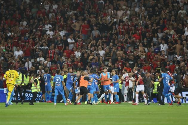 Nice, France, 22nd August 2021. Players scuffle as OGC Nice fans break onto the field of play after Dimitri Payet of Olympique De Marseille threw a bottle of water back into the crowd after it was thrown in his direction during the Lique 1 match at Allianz Riviera Stadium, Nice. Picture credit should read: Jonathan Moscrop Sportimage EDITORIAL USE ONLY. No use with unauthorised audio, video, data, fixture lists, club league logos or live services. Online in-match use limited to 120 images, no video emulation. No use in betting, games or single club league player publications. SPI-1148-0092