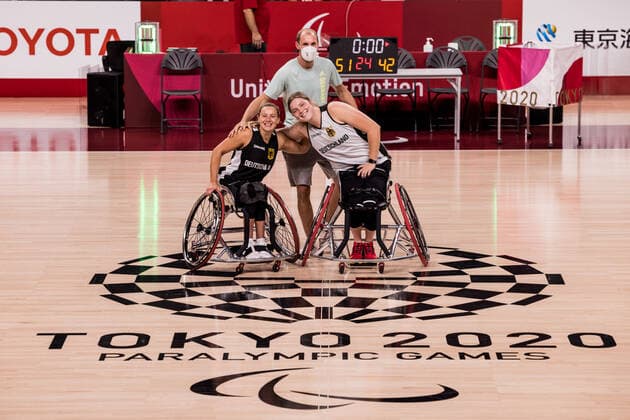Tokyo 2020 Paralympic Games (Rollstuhlbasketball), Pressetraining Damen Deutschland, 23.08.2021 TOKYO, JAPAN 23. August 2021 - Rollstuhlbasketball, Pressetraining der deutschen Damen im Vorfeld der Tokyo 2020 Paralympic Games am 26.08.2021 in der Ariake Arena in Tokyo Japan. Svenja Mayer ( 13, Deutschland), Andre Hopp (Assistant Coach Deutschland), Barbara Gross ( 15, Deutschland) posieren mit dem Logo Copyright: xBEAUTIFULxSPORTS Wunderlx