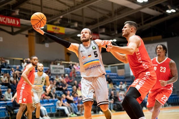 Testspiel Saison 2021 2022 Basketball Medipolis SC Jena vs s.Oliver Würzburg am 28.8.2021. Erstes Spiel mit Zuschauer in der Sparkassen Arena seit 1 1 2 Jahren. v.li. Nico Brauner (Jena) beim Korbleger gegen Filip Stanic (Würzburg) Sparkassen Arena Jena