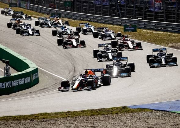 ZANDVOORT - Max Verstappen (Red Bull Racing) followed by Lewis Hamilton (Mercedes AMG Petronas Motorsport) and other drivers through the Tarzan bend during the start of the Dutch Grand Prix at the Zandvoort circuit. REMKO DE WAAL Grand Prix xVIxANPxSportx xxANPxIVx