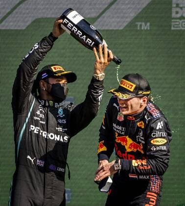 ZANDVOORT - Lewis Hamilton (Mercedes) sprays champagne over Max Verstappen (Red Bull) after winning the Dutch Grand Prix at the Zandvoort circuit. REMKO DE WAAL Grand Prix xVIxANPxSportx xxANPxIVx