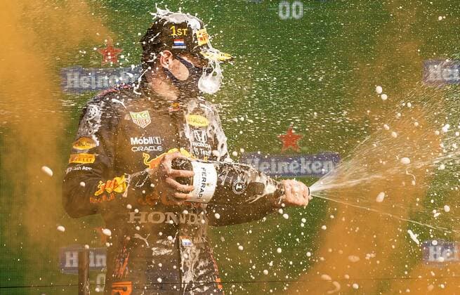 ZANDVOORT - Max Verstappen (Red Bull) sprays champagne on the podium after winning the Dutch Grand Prix at the Zandvoort circuit. REMKO DE WAAL Grand Prix xVIxANPxSportx xxANPxIVx