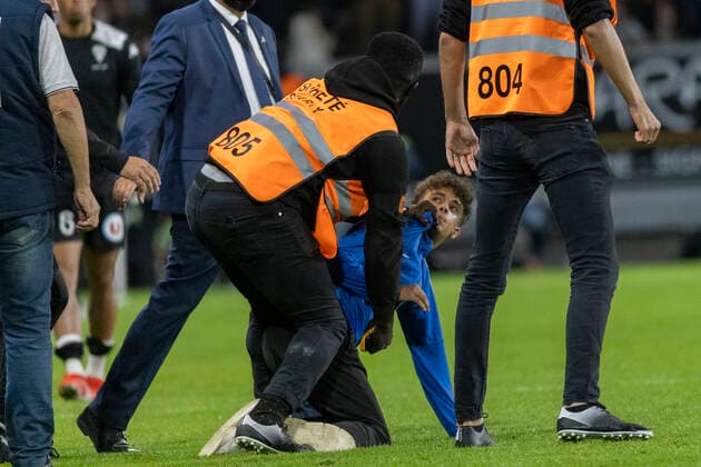 A steward (C) restrains a pitch invader (R) in front of Marseille s Argentine head coach Jorge Sampaoli (REAR) after the French L1 football match between Angers SCO and Marseille, at the Raymond-Kopa Stadium, in Angers, western France, on September 22, 2021  Copyright: xJeremiasxGonzalezx
