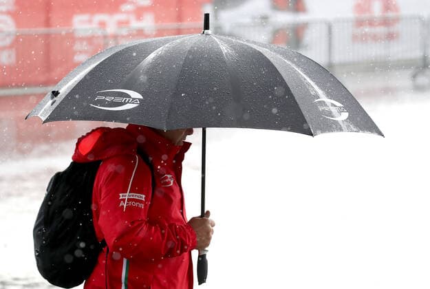 SOCHI, RUSSIA - SEPTEMBER 25, 2021: A man walks in the rain at a parking lot by a paddock area at the Sochi Autodrom racing circuit hosting the 2021 Formula One Russian Grand Prix. The third practice session of the 2021 F1 Russian Grand Prix has been canceled amid heavy rains in Sochi. Sergei Fadeichev TASS  TS111E30