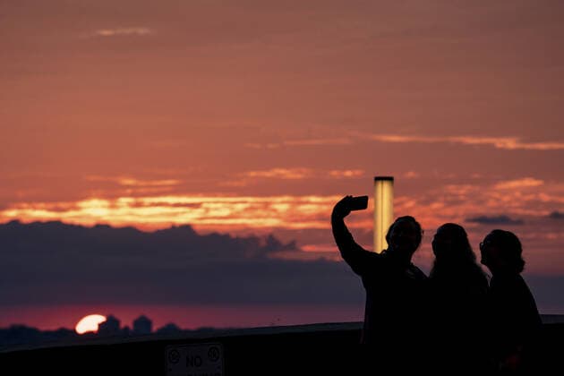 Fans take a selfie as the sun sets before the Kansas City Royals verse the Minnesota Twins game at Kaufman Stadium in Kansas City, Missouri on Friday, October 1, 2021.  KCP20211001103 KYLExRIVAS