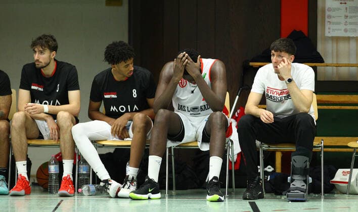 Basketball, Saison 2021 2002, ProB Nord BARMER 2. Basketball Bundesliga, Fünfter Spieltag, ETV Hamburg - RSV Eintracht Stahnsdorf (73:82 nach Verlängerung). Der verletzt ausgeschiedene Mayika Lungongo (2.v.r.) sitzt frustriert auf der Auswechselbank. Rechts neben ihm der ebenfalls verletzte Jack Fritsche. Wandsbek Hamburg