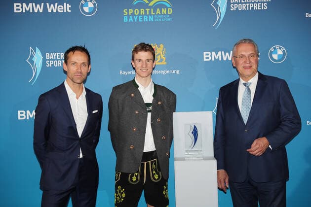 Bayerns Innenminister Joachim Herrmann ehrt Karl Geiger mit dem Bayerischen Sportpreis 2021 als Borschafter des Bayerischen Sports Sven Hannawald, Karl Geiger und der Bayerische Innenminister Joachim Herrmann München Bayern Deutschland BMW Welt