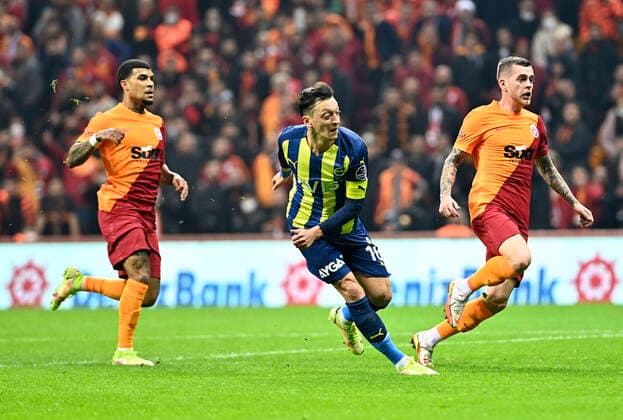 Fußball, EL, Galatasaray Istanbul - Fenerbahce Istanbul DeAndre Roselle Yedlin (L) , Alexandru Cicaldau (R) of Galatasaray and Mesut Ozil of Fenerbahce during the Turkish super league big derby match between Galatasaray and Fenerbahce at NEF stadium in Istanbul , Turkey on November 21, 2021. 