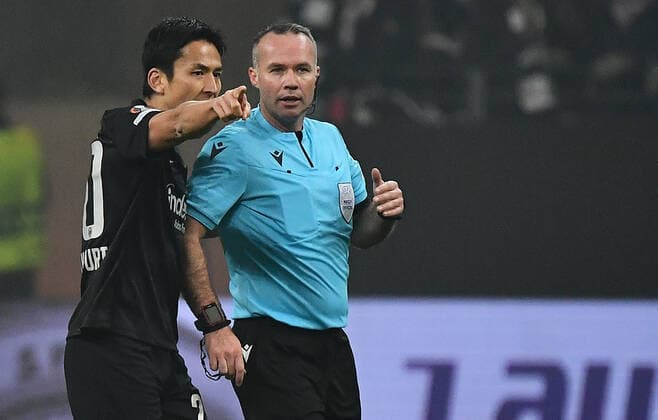 25.11.2021, xjhx, Fussball UEFA Europa League, Eintracht Frankfurt - Royal Antwerpen emspor, v.l. Makoto Hasebe (Eintracht Frankfurt) Schiedsrichter Paul Tierney (ENG) nach einem Boeller Boellerwurf (DFL DFB REGULATIONS PROHIBIT ANY USE OF PHOTOGRAPHS as IMAGE SEQUENCES and or QUASI-VIDEO) Frankfurt am Main