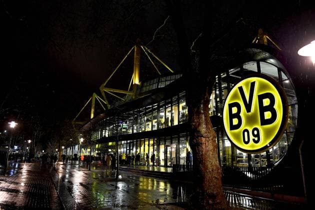 Fußball: 1. Bundesliga, 14. Spieltag, Borussia Dortmund - FC Bayern München am 04.12.2021 im Signal-Iduna-Park in Dortmund (Nordrhein-Westfalen). Blick auf den Fanshop des BVB und dahinter dem Westfalenstadion. Das Logo von Borussia Dortmund leuchtet hell in der Dunkelheit. DFL REGULATIONS PROHIBIT ANY USE OF PHOTOGRAPHS AS IMAGE SEQUENCES AND OR QUASI-VIDEO. Copyright: xChristopherxNeundorfx