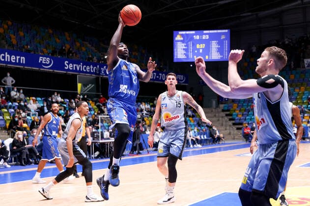 Fraport Skyliners - HAKRO Merlins Crailsheim, easyCredit-BBL Will Cherry (Fraport Skyliners, 29) steigt hoch zum Korb. Rechts Fabian Bleck (Merlins Crailsheim, 9), im Hintergrund Bogdan Radosavljevic (Merlins Crailsheim, 15). Basketball-Spiel des easyCredit BBL zwischen den Fraport Skyliners und HAKRO Merlins Crailsheim am 5. Dezember 2021 in der Fraport-Arena in Frankfurt am Main., Frankfurt am Main Hessen Deutschland Fraport-Arena