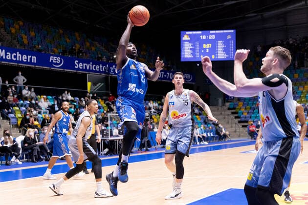 Fraport Skyliners - HAKRO Merlins Crailsheim, easyCredit-BBL Will Cherry (Fraport Skyliners, 29) steigt hoch zum Korb. Bogdan Radosavljevic (Merlins Crailsheim, 15) und Fabian Bleck (Merlins Crailsheim, 9) können nicht mehr eingreifen. Basketball-Spiel des easyCredit BBL zwischen den Fraport Skyliners und HAKRO Merlins Crailsheim am 5. Dezember 2021 in der Fraport-Arena in Frankfurt am Main., Frankfurt am Main Hessen Deutschland Fraport-Arena