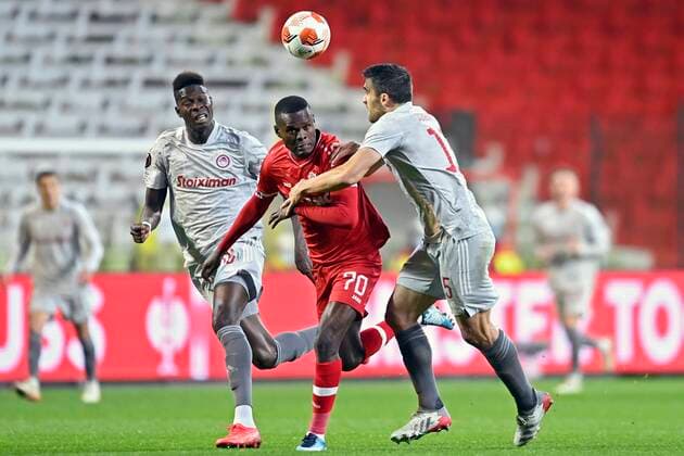 ANTWERPEN, BELGIUM - DECEMBER 09 : Ally Samatta Mbwana forward of Antwerp FC is challenged by Pape Abou Cisse defender of Olympiacos FC and Sokratis Papastathopoulos defender of Olympiacos FC during the UEFA Europa League Group Stage - Group D match between Antwerp FC and Olympiacos FC at the Bosuil stadium on December 09, 2021 in Antwerpen, Belgium, 9 12 2021 ( Antwerp FC v Olympiacos FC : UEFA Europa League PhotoNews Panoramic 