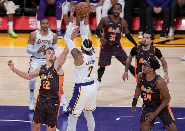 December 12, 2021, Los Angeles, California, USA: Franz Wagner 22 of the Orlando Magic tries to block a shot by Camelo Anthony 7 of the Los Angeles Lakers during their regular season NBA, Basketball Herren, USA game on Friday December 3, 2021 at the Staples Center in Los Angeles, California. Lakers defeat Magic, 106-94. PI Los Angeles USA - ZUMAp124 20211212_zaa_p124_027 Copyright: xJAVIERxROJASx