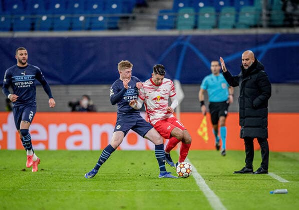Leipzigs Dominik Szoboszlai (weiss) gegen Manchesters Kevin De Bruyne vor den Augen von Pep Guardiola. Fussball UEFA Champions League, 6. Spieltag: RB Leipzig - Manchester City 2:1. 7. Dezember 2021: Leipzig (Sachsen), Red Bull Arena. RB Leipzig - Manchester City 2:1