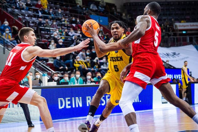 Justin Simon (MHP RIESEN Ludwigsburg 5) zwischen li: Oleksandr Lypovyy (BC Prometey 11) und re. Sean Evans (BC Prometey 5) beim BCL-Spiel: MHP RIESEN Ludwigsburg vs. BC Prometey am 21.12.2021 in Ludwigsburg (MHPArena) Deutschland Ludwigsburg. 21.12.21 Basketball , 21.12.2021, Ludwigsburg (Deutschland)