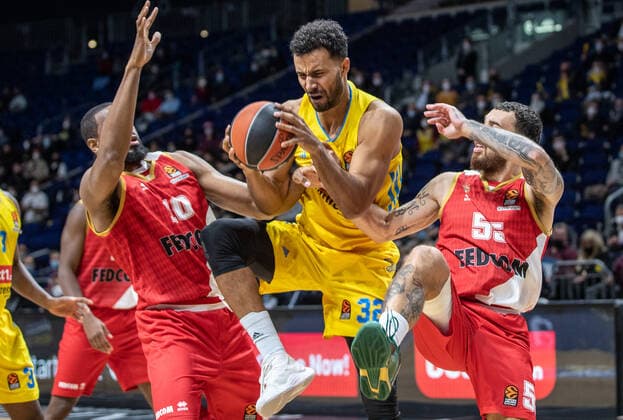 Basketball: EuroLeague, ALBA Berlin - AS Monaco, 17. Spieltag, Mercedes-Benz Arena. ALBAs Johannes Thiemann (M) kaempft gegen Mike James (r) und Will Thomas von AS Monaco um den Ball. ALBA Berlin - AS Monaco