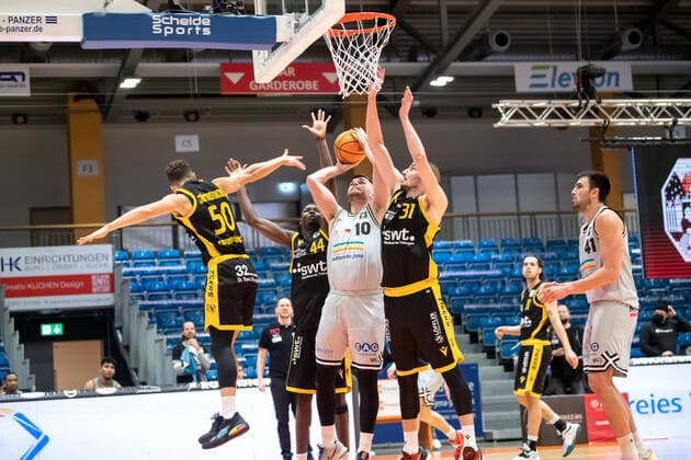 BARMER 2. Basketball Bundesliga Saison 2021 2022 Spieltag 16 am 27.12.21 Medipolis SC Jena vs Tigers Tübingen Mitte: Julius Wolf (Jena) beim Korbleger gegen 3 Gegenspieler. v.re. Daniel Keppeler (Tübingen), Bakary Dibba (Tübingen) und Joanic Grüttner Bacoul (Tübingen) Sparkassen Arena