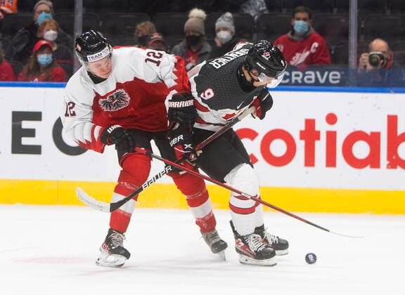 December 28, 2021, EDMONTON, AB, CANADA: Canada s Dylan Guenther (9) and Austria s Tobias Sablattnig (12) battle for the puck during second period IIHF World Junior Hockey Championship action in Edmonton on Tuesday, December 28, 2021. Dylan Guenther Tobias Sablattnig  - ZUMAc35_ 20211228_zaf_c35_079 Copyright: xJasonxFransonx