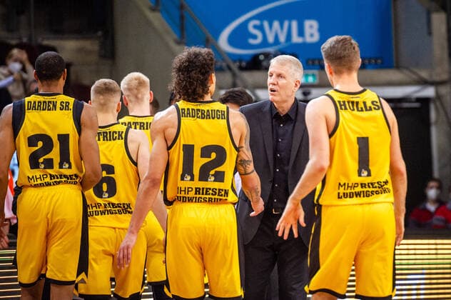 John Patrick (Headcoach MHP RIESEN Ludwigsburg) mit Jonah Radebaugh (MHP RIESEN Ludwigsburg 12) und Jordan Hulls (MHP RIESEN Ludwigsburg 1) beim BBL-Spiel: MHP Riesen Ludwigsburg - JobStairs Giessen 46ers am 29.12.2021 in Ludwigsburg (MHPArena) Deutschland Ludwigsburg. 29.12.21 Basketball , 29.12.2021, Ludwigsburg (Deutschland)
