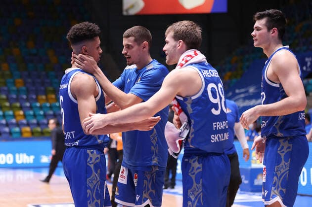 Fraport Skyliners - MLP Academics Heidelberg, easyCredit-BBL Len Adam Schoormann (Fraport Skyliners, 6) bekommt Glückwünsche von seinen Mitspielern Lukas Wank (Fraport Skyliners, 0), Felix Hecker (Fraport Skyliners, 98) und Brooks DeBisschop (Fraport Skyliners, 22). Basketball-Spiel des easyCredit BBL zwischen den Fraport Skyliners und den MLP Academics Heidelberg am 30. Dezember 2021 in der Ballsporthalle in Frankfurt am Main., Frankfurt am Main Hessen Deutschland Ballsporthalle
