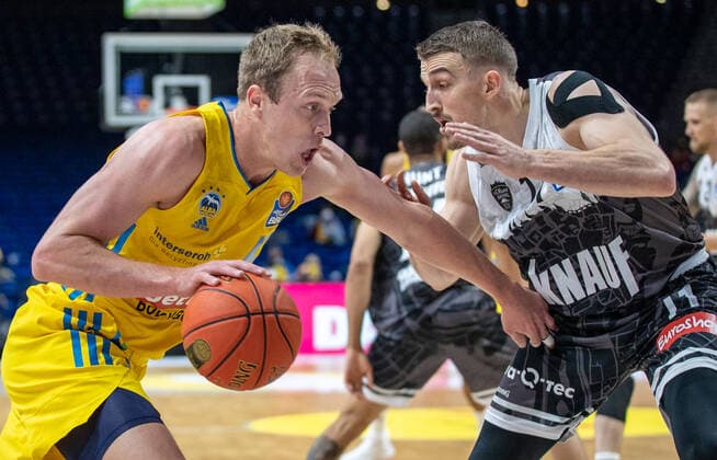 31.12.2021, Berlin, Basketball, 1. Bundesliga, easyCredit BBL, Hauptrunde, 14.Spieltag, Mercedes Benz Arena: ALBA Berlin - s.Oliver Wuerzburg. ALBAs Luke Sikma (l) kaempft gegen Tomasz Gielo von s.Oliver Wuerzburg um den Ball. ALBA Berlin - s.Oliver Wuerzburg