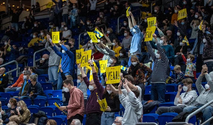 31.12.2021, Berlin, Basketball, 1. Bundesliga, easyCredit BBL, Hauptrunde, 14.Spieltag, Mercedes Benz Arena: ALBA Berlin - s.Oliver Wuerzburg. Fans von ALBA Berlin stehen mit Klatschpappen in der Halle. ALBA Berlin - s.Oliver Wuerzburg