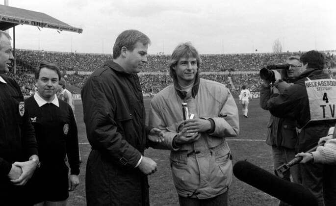 04.03.89 VfB Stuttgart - FC Bayern München Deutschland, Stuttgart, 04.03.1989, Fussball, Bundesliga, VfB Stuttgart - FC Bayern München (1:2): Rainer Holzschuh (kicker) verleiht Jürgen Klinsmann (VfB Stuttgart) das goldene Leser k.