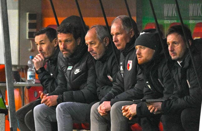 16.01.2022, Fussball 1. Bundesliga 2021 2022, 19. Spieltag, FC Augsburg - Eintracht Frankfurt, in der WWK-Arena Augsburg, v.li: Co-Trainer Tobias Zellner (Augsburg), Trainer Markus Weinzierl (FC Augsburg), Co-Trainer Rainer Maurer (FC Augsburg), Sportdirektor Stefan Reuter (FC Augsburg) nachdenklich auf der Bank.
