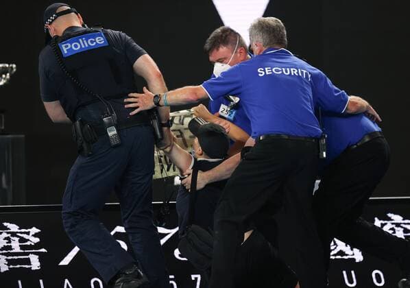 Mandatory Credit: Photo by Ella Ling Shutterstock (12778014bg) A protester is tackled by security and police during the Men s Singles final Australian Open, Day Fourteen, Tennis, Melbourne Park, Melbourne, Australia - 30 Jan 2022 Australian Open, Day Fourteen, Tennis, Melbourne Park, Melbourne, Australia - 30 Jan 2022 Copyright: xEllaxLing Shutterstockx 12778014bg