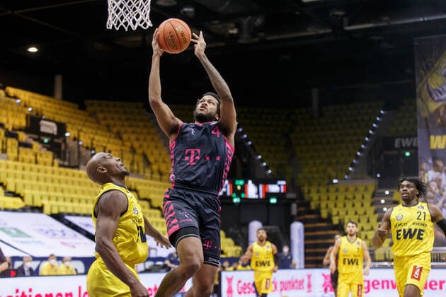 Oldenburg, Niedersachsen, DEU, Justin Gorham (rechts, Telekom Baskets Bonn) und Rickey Paulding (links, EWE Baskets Oldenburg). EWE Baskets Oldenburg vs. Telekom Baskets Bonn. 1. Basketball-Bundesliga Saison 2021 2022, 19. Spieltag, Grosse EWE Arena. EWE Baskets Oldenburg vs. Telekom Baskets Bonn